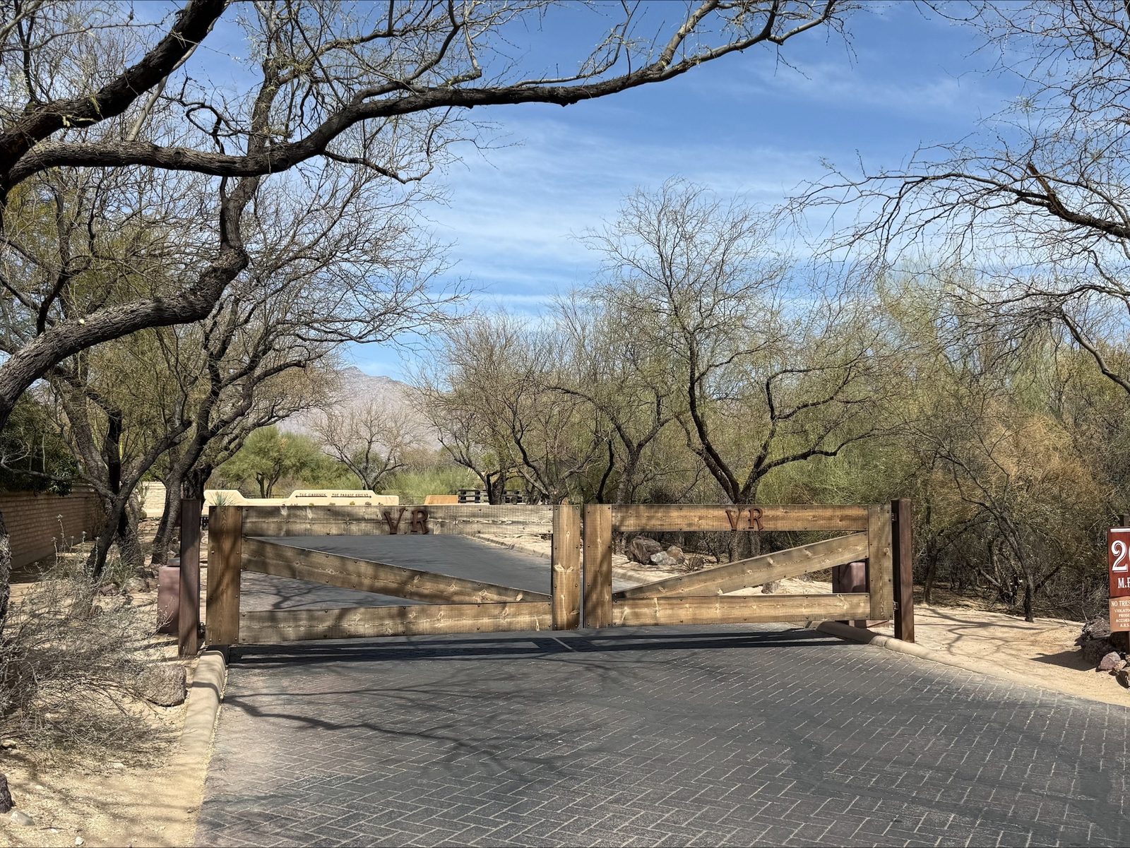 Rustic timber ranch entry gate with brand detail and paver drive — Signal Gates