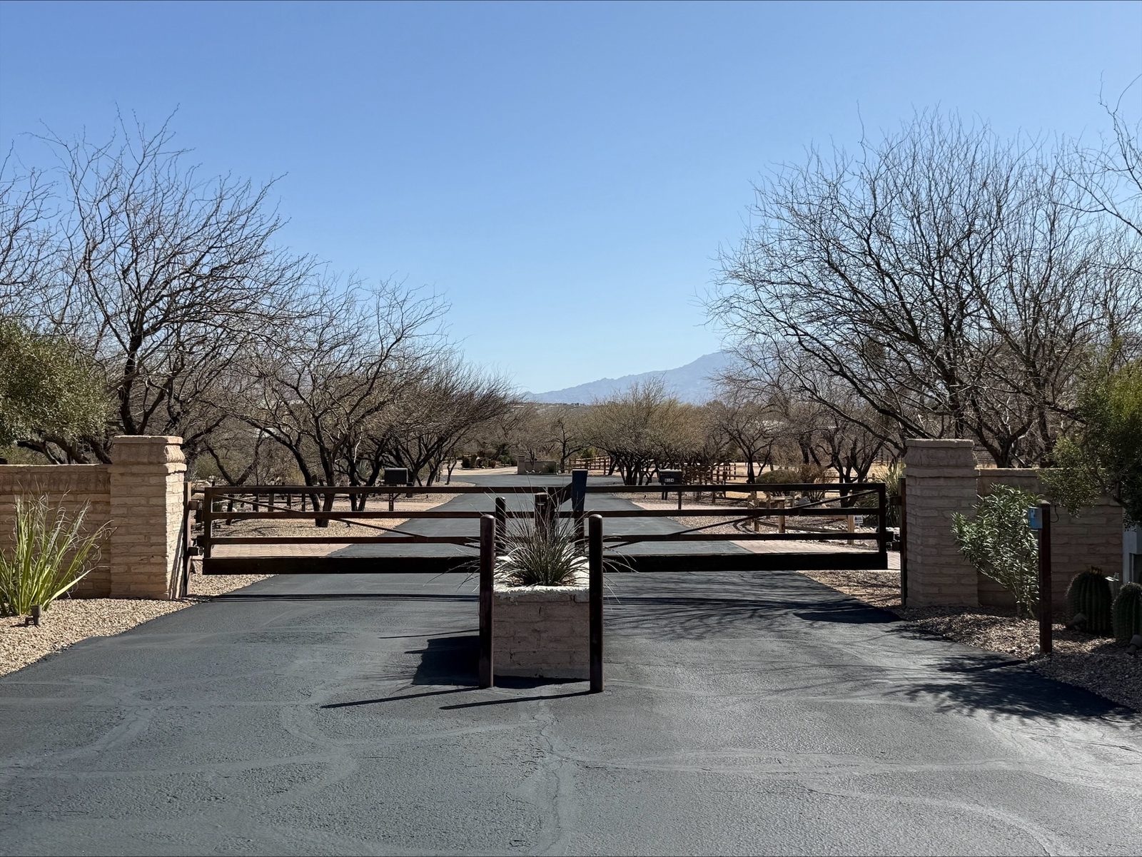 Ranch estate entry gate with stone pillars and mountain view — Signal Gates