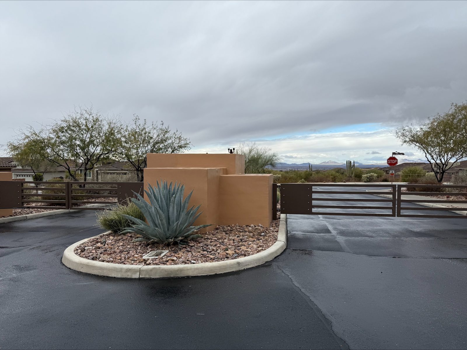 Southwestern adobe community entrance with custom horizontal-rail gate — Signal Gates